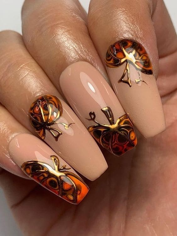Long, coffin-shaped nude nails with pumpkins