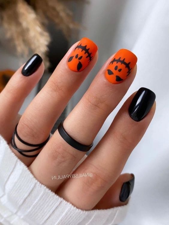 Short, black, and orange nails with a jack o'lantern