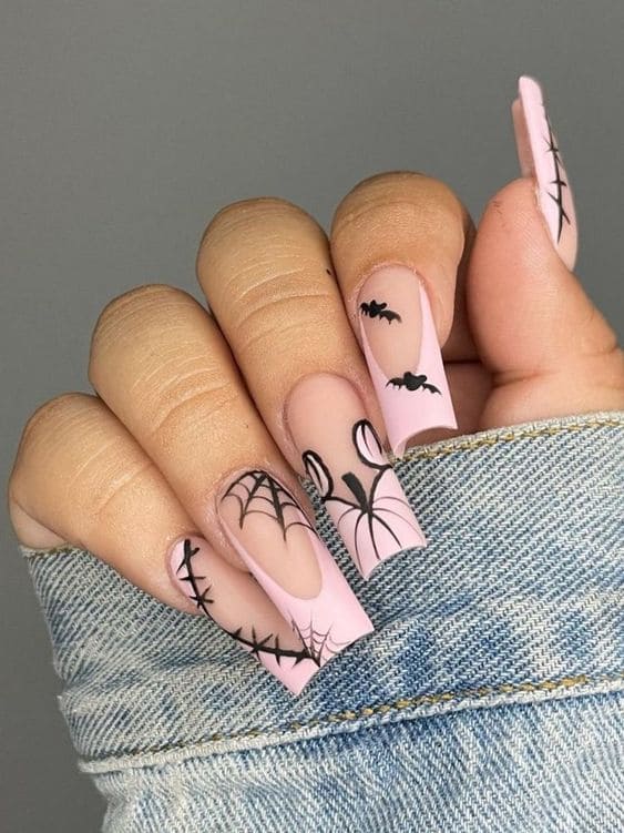 Long pink acrylic nails with a pumpkin design 