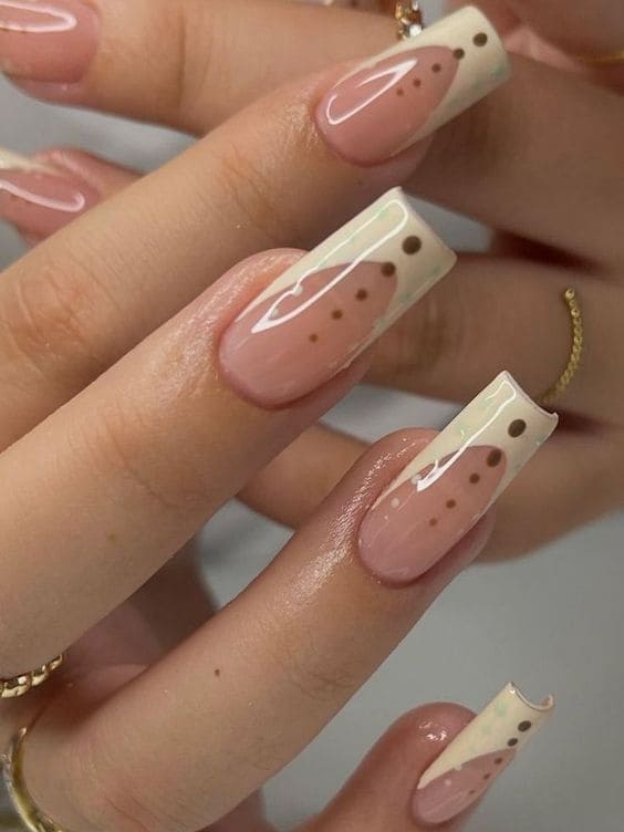 Long, coffin-shaped beige French tips with geometric dots