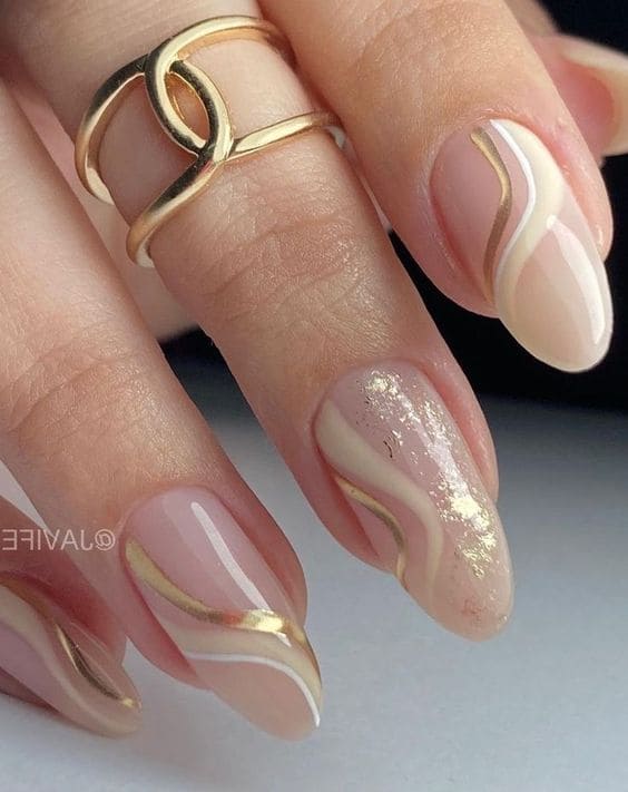 Beige and gold swirl nail design