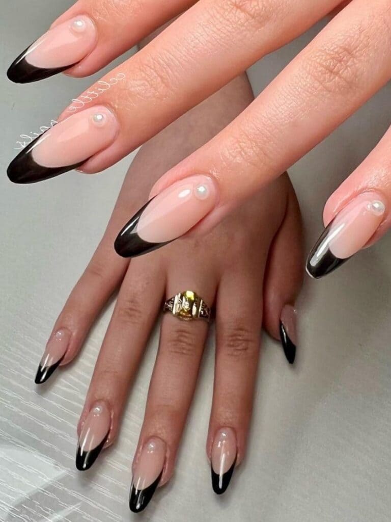 Long black French tip nails with pearl accents 