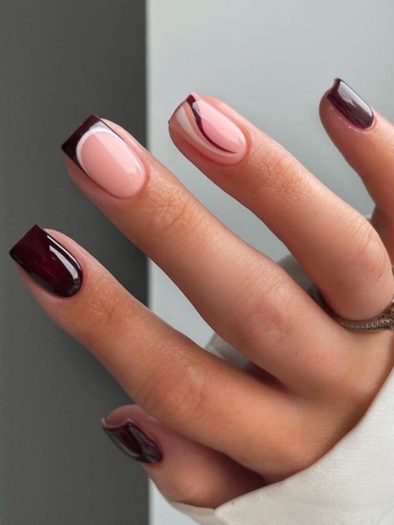 Short dark brown nails with a French tip and swirl 