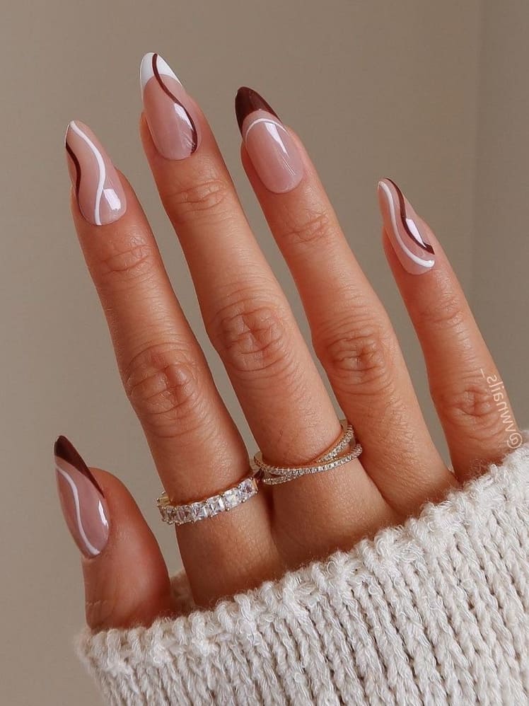 Brown and white French tip nails with swirl designs 