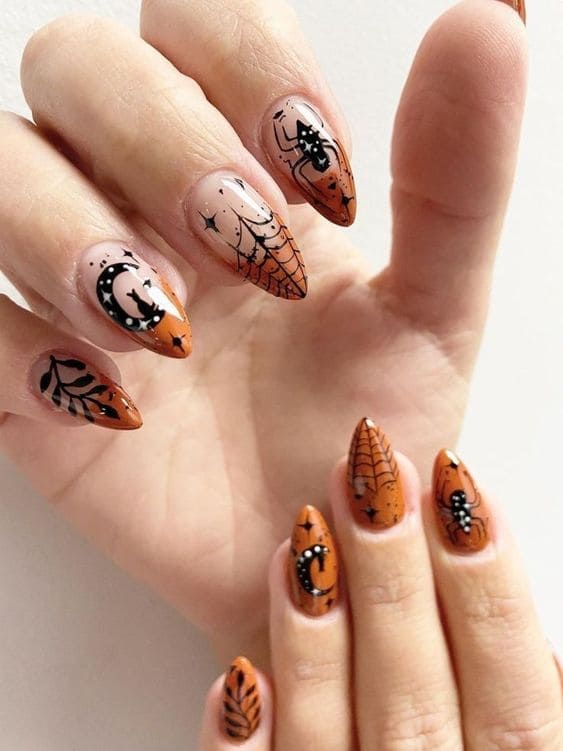 Short, stiletto-shaped burnt orange nails with Halloween elements
