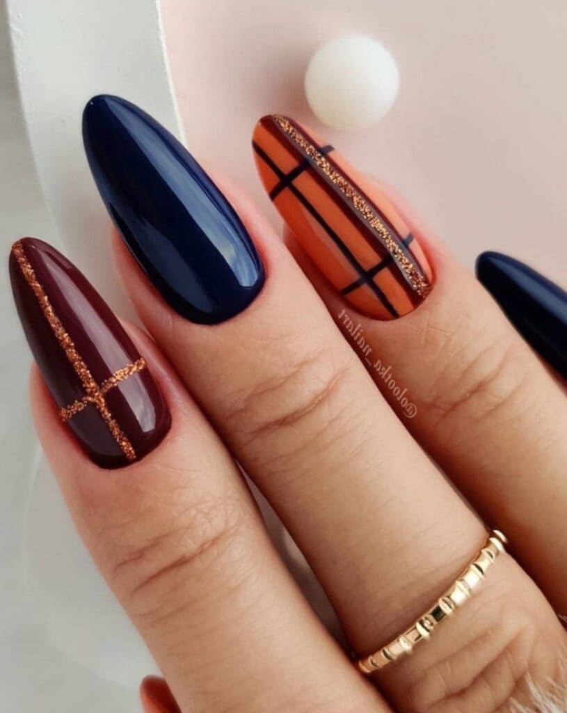 Black, orange, and burgundy plaid nails