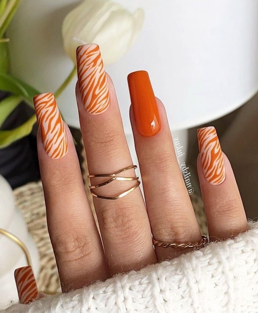 Long, coffin-shaped, zebra-print orange nails