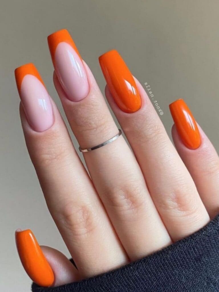Long, coffin-shaped orange nails with French tips