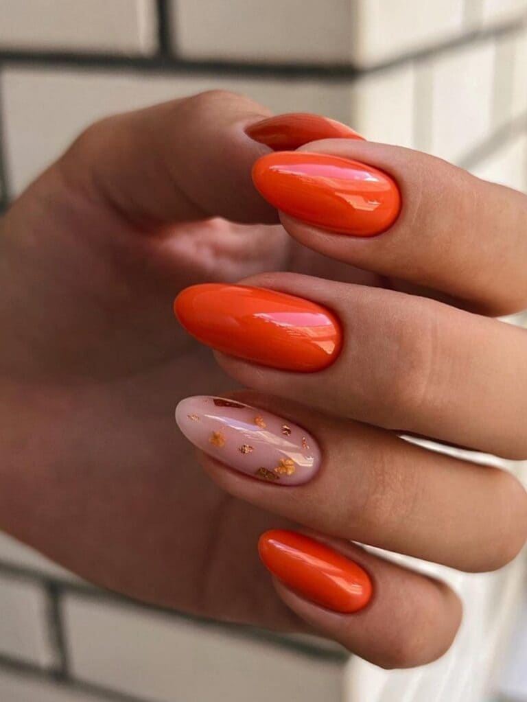 Dark orange nails with a gold foil accent