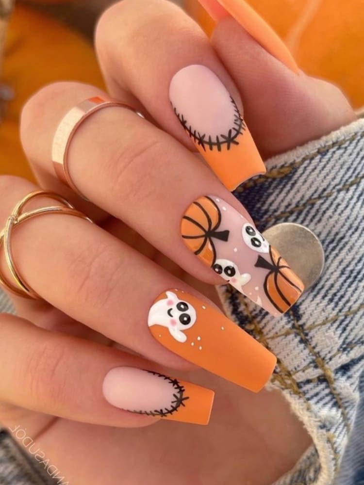 Long, coffin-shaped, matte burnt orange nails with pumpkins and ghosts