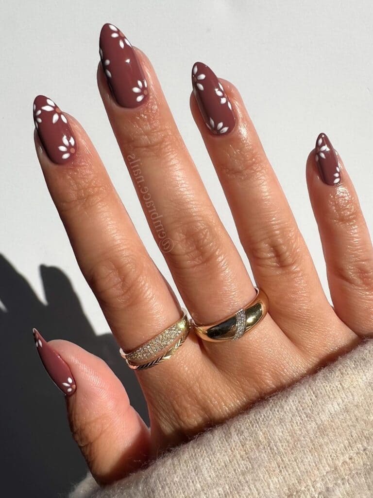 almond-shaped brown nails with fall flower designs