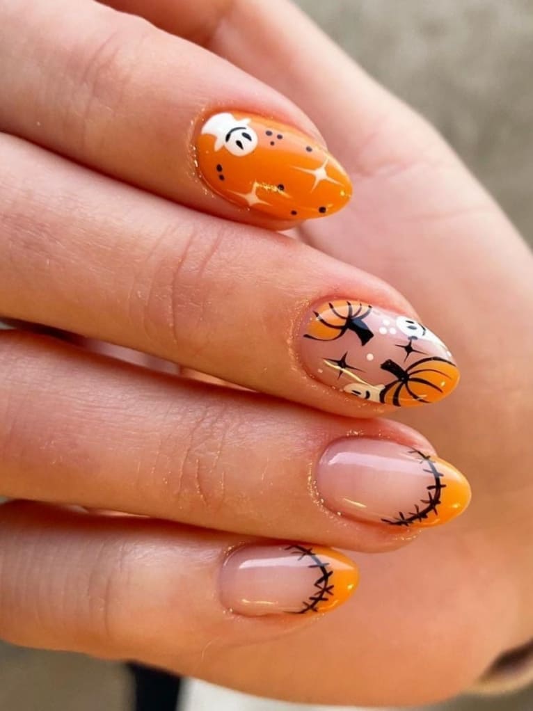 short orange nails with pumpkins, stitches, and ghosts