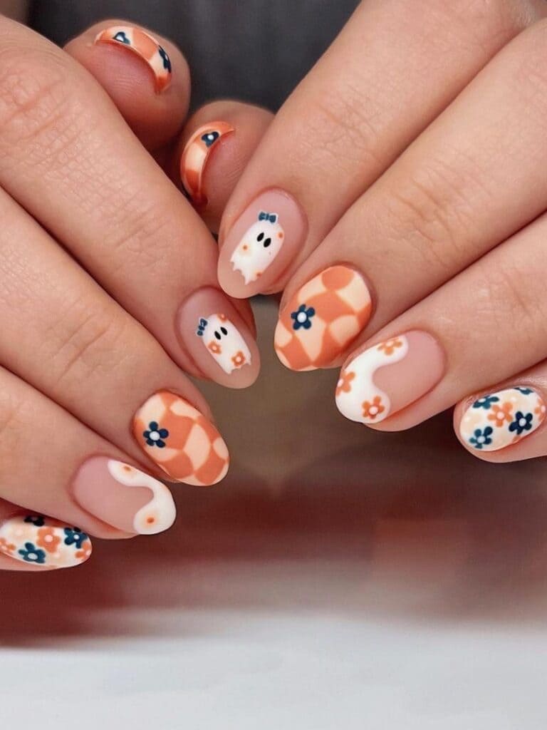 Two-tone neutral nails with flowers and ghosts
