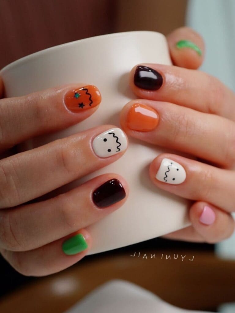 Various Halloween-colored short nails with a simple ghost design