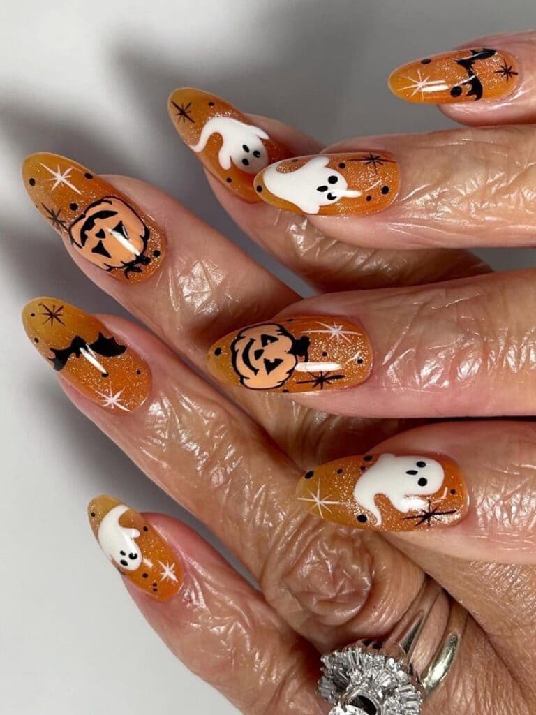 Glittery burnt orange nails with Halloween elements