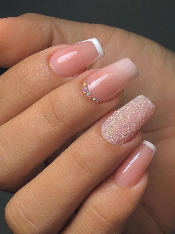 Long, coffin-shaped nude ombre nails with glitter and French tips
