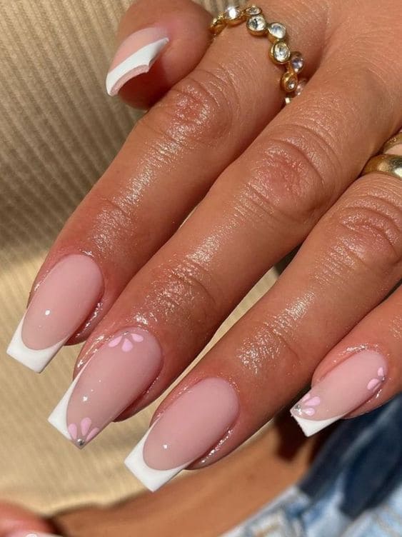 Long white acrylic French tips with baby pink flowers