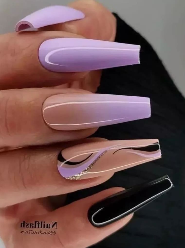 Long, coffin-shaped lavender and black ombre nails with swirls