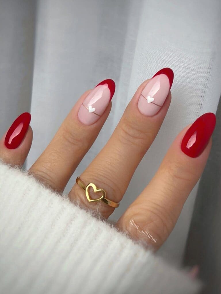 Red French manicure with metal heart accent
