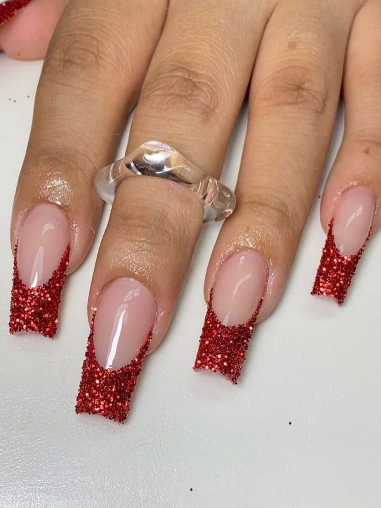 long, coffin-shaped, glittery red French manicure