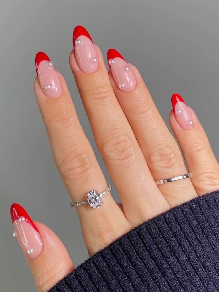 Round-shaped, red French-tip nails with pearls