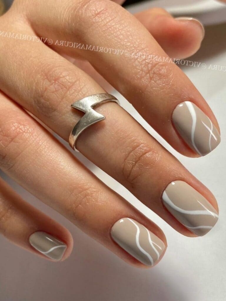 Nude nails with white swirls
