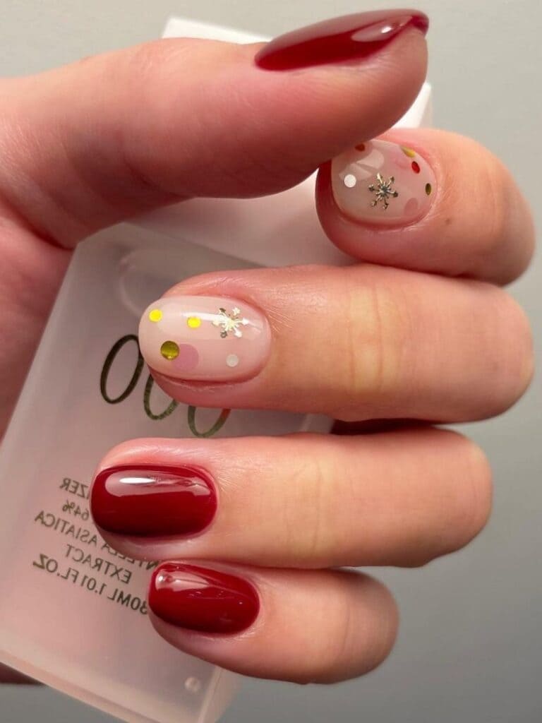 Short, dark red, and milky nails with gold snowflakes 