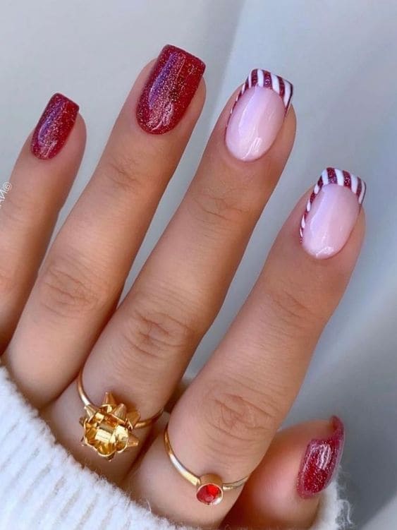 Short, glittery red nails and candy cane-shaped French tips