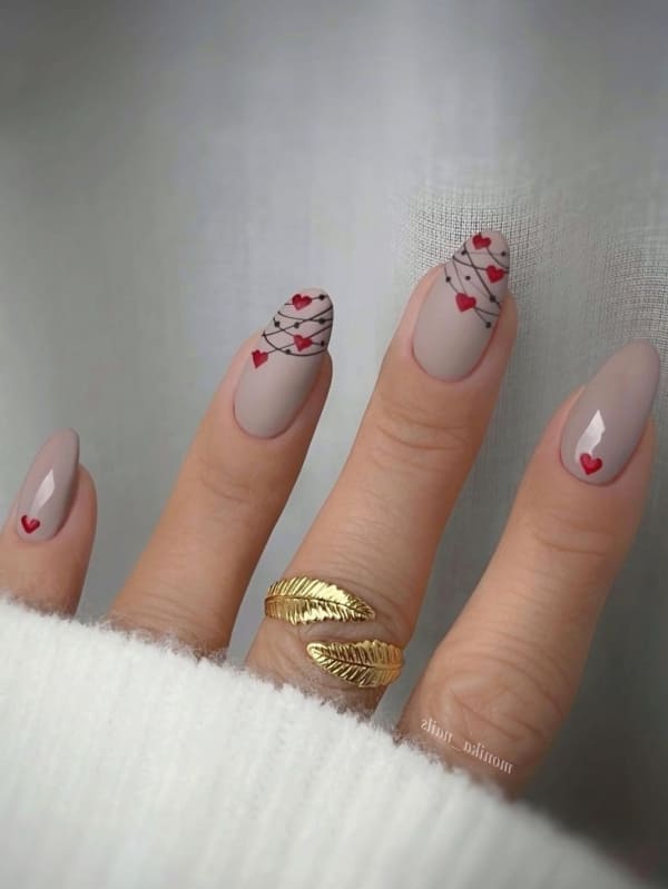 Nude nails with abstract red heart tips