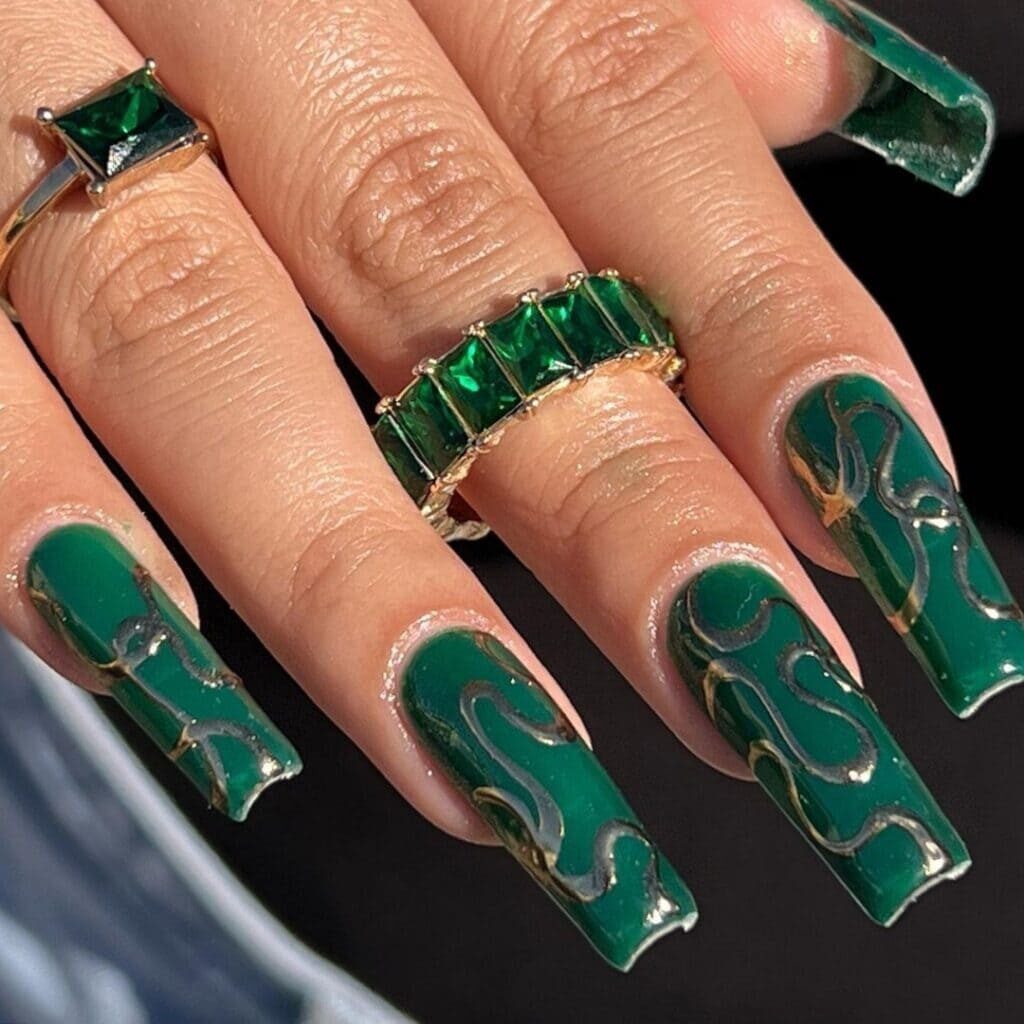 Long, acrylic, green nails with golden squiggles