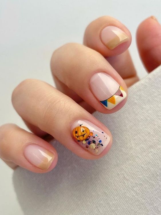 Short, beige French tips with a cute pumpkin accent 