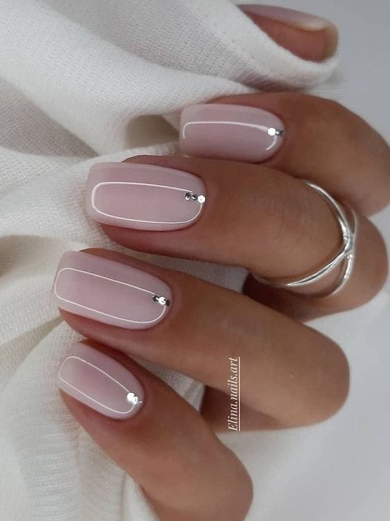 Milky white short nails with a rhinestone accent 
