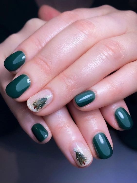 Short, emerald green nails with a Christmas tree