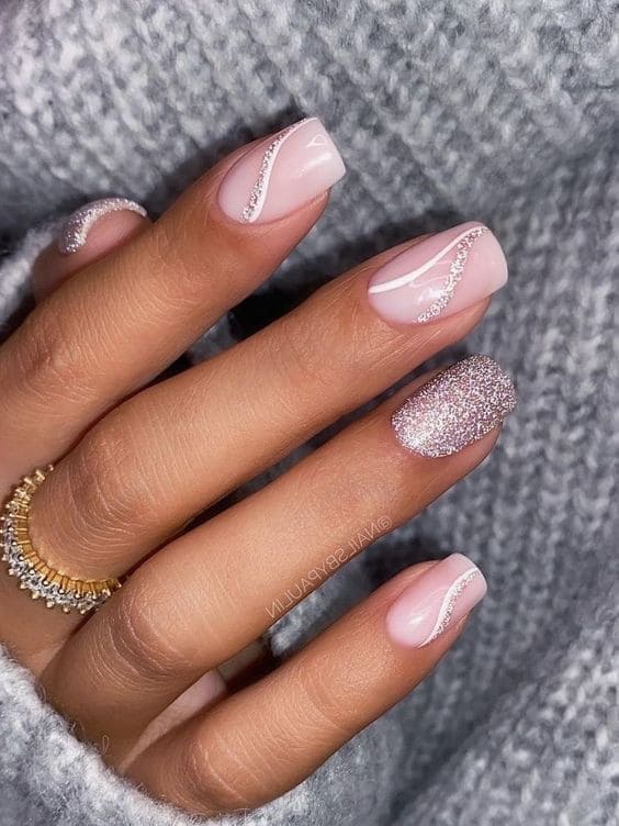 short, light pink glitter nails with swirls 