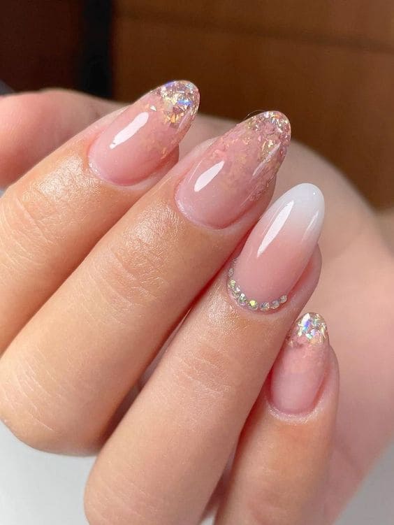 nude ombre nails with glitter and gems