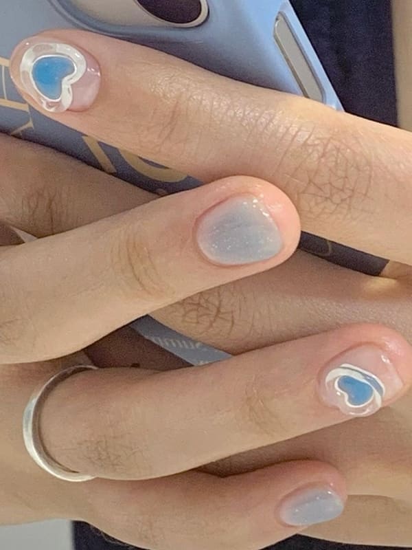 light blue cheek nails with heart accents