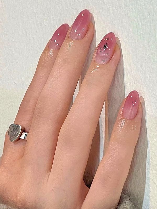 translucent pink ombre nails with a star in chrome