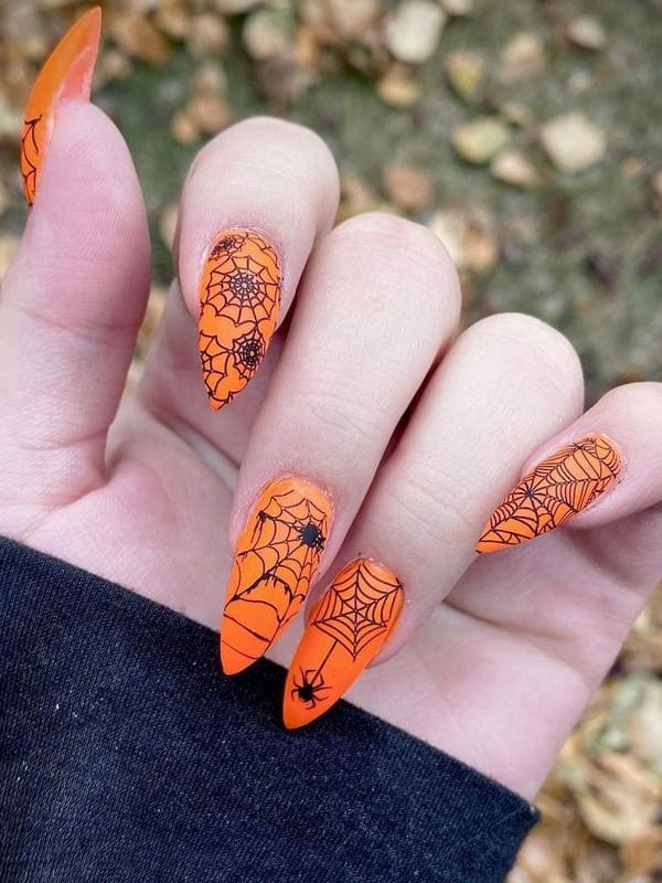 orange nails with spider webs 