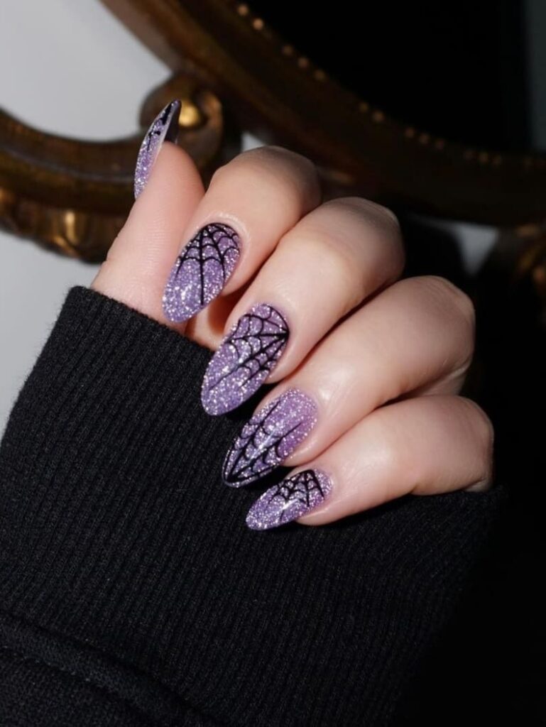 shimmery purple nails with spider webs
