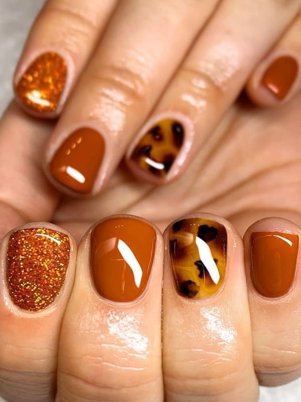 burnt orange with glitter nails 