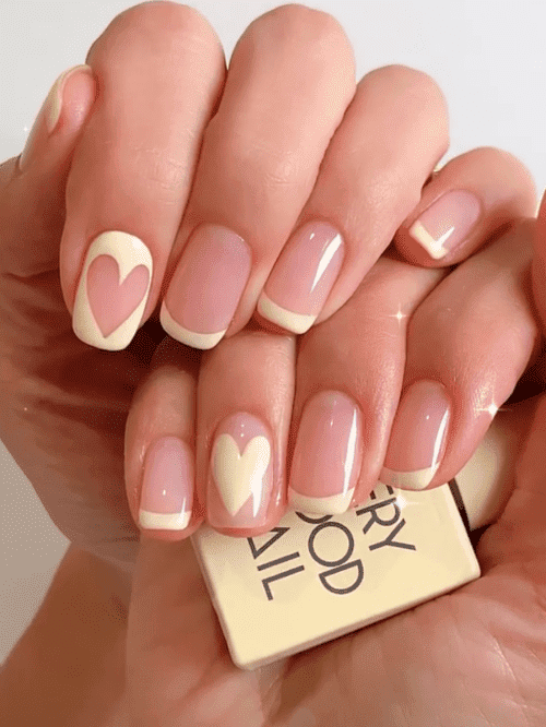 Korean spring nail design: pastel yellow French tips with a heart