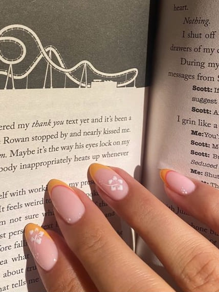 cute summer nails: pastel orange French tips with hibiscus flowers