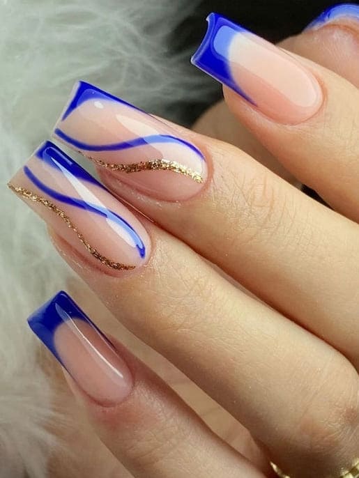 royal blue nails: gold glitter swirls 