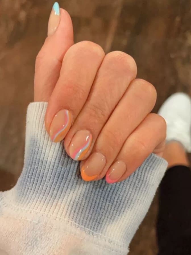 short summer nails: peach and pink French tips with swirls 